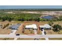 Home exterior shot with surrounding neighborhood homes and green space in the background at 113 Annapolis Ln, Rotonda West, FL 33947