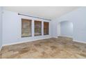Inviting bedroom featuring three windows, tiled flooring and a connecting arched doorway at 1155 Osceola Blvd, Englewood, FL 34223