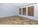 Spacious bedroom with natural light from three windows and tile flooring at 1155 Osceola Blvd, Englewood, FL 34223