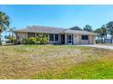 Charming single-story home featuring a screen door and a lush, green lawn at 11869 Newgate Ave, Port Charlotte, FL 33981
