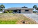 Well-kept single-story home with a screen door and a tidy landscaped front yard at 11869 Newgate Ave, Port Charlotte, FL 33981