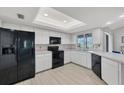 Functional kitchen featuring white cabinets, black appliances, and a window view to the outdoors at 119 Fairway Rd, Rotonda West, FL 33947