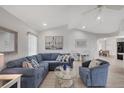 Cozy living room showcasing a comfortable blue sectional sofa, a glass coffee table, and a bright open floor plan at 119 Fairway Rd, Rotonda West, FL 33947