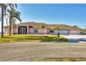 Charming single-story home featuring a three-car garage, arched windows, and mature landscaping at 12445 Krome Ave, Port Charlotte, FL 33981
