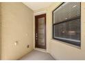 Exterior entry with wooden door with decorative glass insert and window with blinds at 1318 Ballota Ln, North Port, FL 34289
