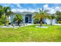 Charming single story home featuring decorative stone accents and a lush green lawn at 13348 Boabadilla Ln, Port Charlotte, FL 33981