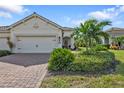 Charming home featuring a brick driveway, lush landscaping, and a welcoming entryway at 1339 Backspin Dr, Englewood, FL 34223