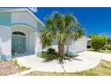 Charming home featuring light blue accents, a well-maintained lawn, and a convenient two-car garage at 162 Fairway Rd, Rotonda West, FL 33947