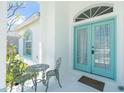 Inviting front porch with decorative chairs and a small table next to the charming double doors at 162 Fairway Rd, Rotonda West, FL 33947