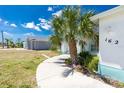 Beautiful home with a curved walkway and a mature palm tree in the front yard on a sunny day at 162 Fairway Rd, Rotonda West, FL 33947