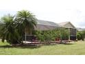 An ample screened-in patio with tropical landscaping provides a serene backyard living space at 169 Fairway Rd, Rotonda West, FL 33947