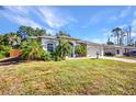 Home exterior featuring a well-manicured lawn, an attached garage, and mature landscaping at 1962 Remus Ave, North Port, FL 34286