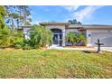 Charming home exterior featuring a screened front entry, mature landscaping, and a well-kept lawn at 1962 Remus Ave, North Port, FL 34286