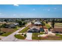 Spacious property features a home with a pool, surrounded by a well-manicured lawn, landscaped areas, and a golf course nearby at 204 Bunker Rd, Rotonda West, FL 33947