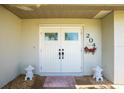 Welcoming double front doors with decorative elements and small shrubs, creating an inviting entrance to the home at 204 Bunker Rd, Rotonda West, FL 33947