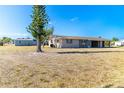 Single-story home with a sprawling lawn, shed, and tree, set under a clear blue sky in a quiet neighborhood at 2075 Georgia Ave, Englewood, FL 34224