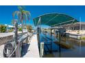 View of the Boat Dock. The dock is equipped with boat lifts and a covered area, adding to the waterfront appeal at 2673 Titania Rd, Englewood, FL 34224