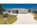 Charming single-story home with a well-manicured lawn and a spacious driveway leading to an attached garage at 2673 Titania Rd, Englewood, FL 34224
