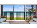 Enjoy ocean views from this screened-in balcony with comfortable seating and a decorative rug at 2950 N Beach Rd # B324, Englewood, FL 34223