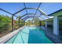 Inviting in-ground pool, screen enclosure, and ample patio space for relaxing by the water at 2957 Montgomery Dr, Port Charlotte, FL 33981