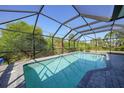 Beautiful in-ground pool surrounded by a screened enclosure and brick pavers for outdoor enjoyment at 2957 Montgomery Dr, Port Charlotte, FL 33981