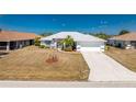 Charming single-story home featuring mature landscaping, a two-car garage, and a concrete driveway at 311 Boundary Blvd, Rotonda West, FL 33947