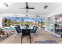 A covered lanai with table and chairs provides ample seating overlooking a screened in pool at 311 Boundary Blvd, Rotonda West, FL 33947