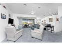 Bright, spacious living room with large windows and neutral carpet flows nicely to lanai and kitchen at 311 Boundary Blvd, Rotonda West, FL 33947