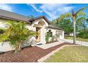 Inviting front entrance with a decorative door, well-manicured landscaping, and freshly mulched flowerbeds at 3593 Birmingham Ln, North Port, FL 34288