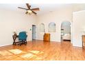 Spacious living area featuring wood-look floors, neutral walls, and arched doorways to other rooms at 3593 Birmingham Ln, North Port, FL 34288