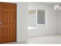 Light-filled foyer featuring a wood-look door, tiled floors, and a window at 360 E Wentworth Cir, Englewood, FL 34223
