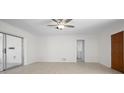 Open living room with light-colored walls, wood-look floors, and sliding glass doors to the outside at 360 E Wentworth Cir, Englewood, FL 34223