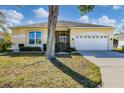 Charming single-story home featuring a well-maintained lawn, arched window, and a two-car garage at 4115 Hemingway Dr, Venice, FL 34293