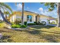 Attractive home with a well-manicured lawn, mature palm trees, and an attached two-car garage at 4115 Hemingway Dr, Venice, FL 34293