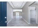 Bright foyer with tray ceilings and gray wood-look tile flooring leading into the spacious and open living area at 5273 Gillot Blvd, Port Charlotte, FL 33981
