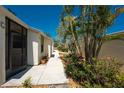Beautifully landscaped walkway lined with trees, flowers, and immaculate villas under a clear sky at 6796 Gasparilla Pines Blvd # 63, Englewood, FL 34224