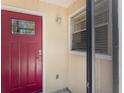 Welcoming front door with a beautiful red door and sidelight at 6796 Gasparilla Pines Blvd # 63, Englewood, FL 34224