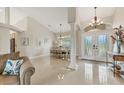 Bright foyer with high ceilings, tile floors, and double doors that lead to a formal dining space at 8180 Burwell Cir, Port Charlotte, FL 33981
