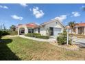 Well-maintained home featuring lush green lawn and manicured hedges along a tiled roof in a sunny neighborhood at 8320 Creekview Ln, Englewood, FL 34224