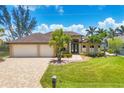 Beautiful home featuring a paver driveway leading to a spacious three-car garage at 8400 Antwerp Cir, Port Charlotte, FL 33981