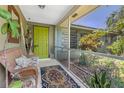 Welcoming front porch with a vibrant green door, offering a charming entrance and curb appeal at 875 Morrison Ave, Englewood, FL 34223