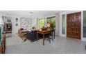 Bright living room featuring large windows, terrazzo flooring, and stylish furnishings at 875 Morrison Ave, Englewood, FL 34223