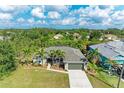 Aerial view of a charming single-story home surrounded by mature trees and lush landscaping at 9211 Koma St, Port Charlotte, FL 33981