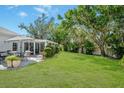Spacious backyard with a patio, lush lawn, privacy wall, and mature trees for a serene outdoor setting at 1 Curacao Cir # 44, Englewood, FL 34223