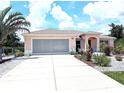 Inviting single-story home featuring a neutral color palette, a well-maintained driveway, and manicured landscaping at 10064 Cocoa Beach St, Port Charlotte, FL 33981