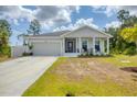 Beautiful single-story home boasting a covered porch and an attached two car garage at 129 David Blvd, Rotonda West, FL 33947