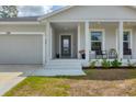 Covered porch area with seating offering a cozy and inviting entrance to the home at 129 David Blvd, Rotonda West, FL 33947