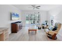 Bright living room with neutral tones, ceiling fan, and sliding glass doors to balcony at 149 Englewood Isles Pkwy # 603, Englewood, FL 34223