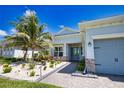 Charming single-story home with well-manicured landscaping, stone accents, and a paved walkway leading to the front door at 15176 Spanish Point Dr, Port Charlotte, FL 33981