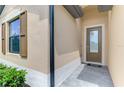 Close up of the front entryway featuring a brown door with a glass panel and sidelight at 1836 W Isles Rd, Port Charlotte, FL 33953
